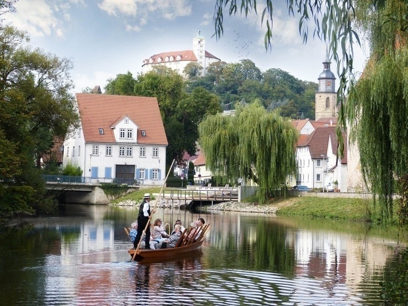 Ein Stocherkahn mit Passagieren gleitet auf einem Fluss entlang, umgeben von malerischen Geb&auml;uden und einem Kirchturm im Hintergrund., &copy; Stadtverwaltung Vaihingen an der Enz