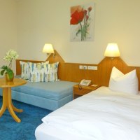 Ein gemütliches Einzelzimmer mit einem Bett, einem kleinen Sofa, einem runden Holztisch und einer Tischlampe. An der Wand hängt ein Blumenbild., © Hotel & Restaurant Sonne Ein gemütliches Einzelzimmer mit einem Bett, einem kleinen Sofa, einem runden Holztisch und einer Tischlampe. An der Wand hängt ein Blumenbild., © Hotel & Restaurant Sonne