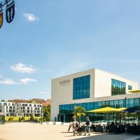Moderner Marktplatz in Remseck mit dem Gebäude 'KUBUS', einem Maibaum mit Wappen und Menschen, die spazieren gehen. Sonniger Tag mit blauem Himmel., © Stuttgart-Marketing GmbH, Sarah Schmid Moderner Marktplatz in Remseck mit dem Gebäude 'KUBUS', einem Maibaum mit Wappen und Menschen, die spazieren gehen. Sonniger Tag mit blauem Himmel., © Stuttgart-Marketing GmbH, Sarah Schmid