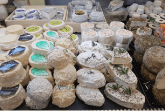Eine Auswahl an franz&ouml;sischen K&auml;sesorten, darunter Ziegenk&auml;se und Brie, auf einem Marktstand pr&auml;sentiert., &copy; K&auml;se Haas