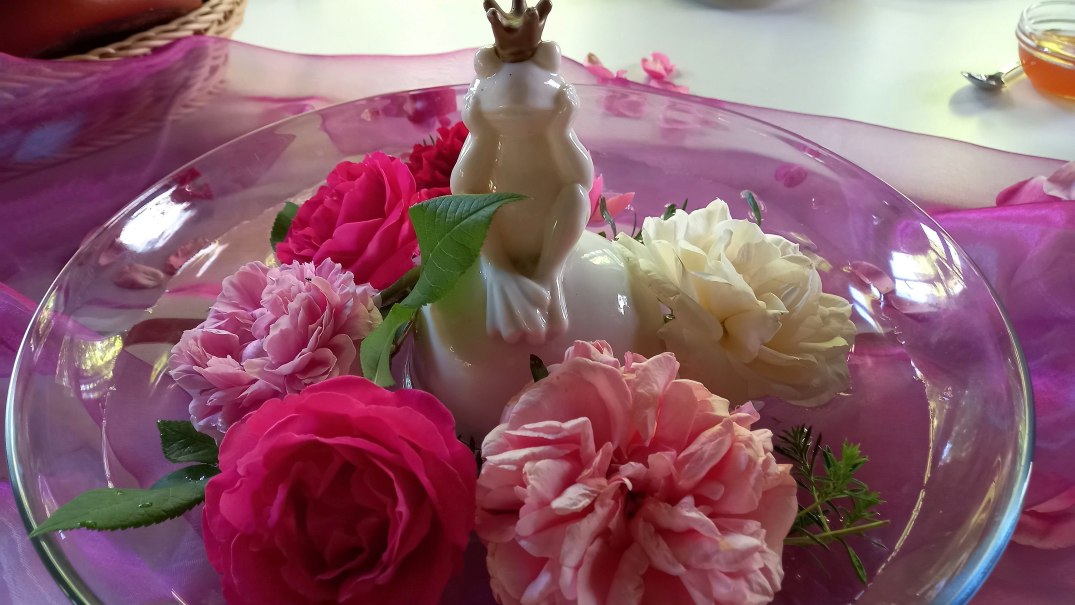 Tischdeko - Glasschale mit Rosen in wei&szlig;, rosa und pink, mittendrin ein wei&szlig;er Porzellanfrosch mit goldener Krone, &copy; Petra Natzkowski