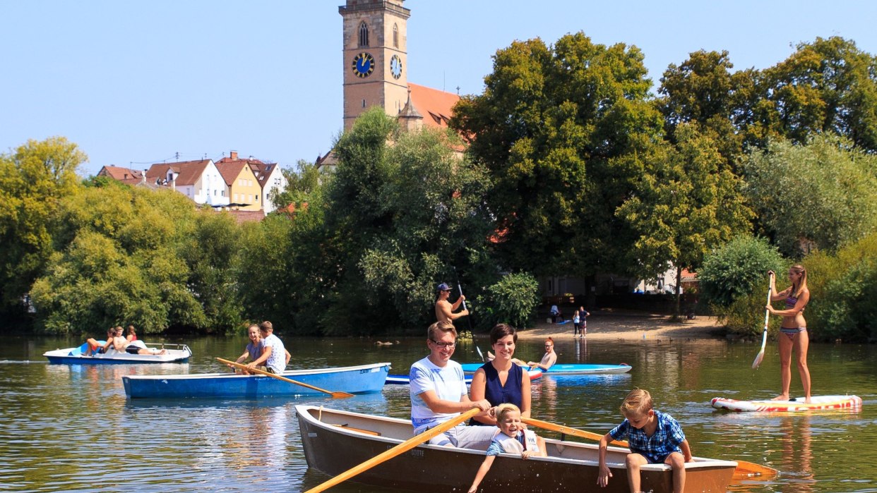 Familien und Freunde genießen eine Bootspartie auf einem See, während im Hintergrund ein Kirchturm zu sehen ist., © H. Bergmüller Familien und Freunde genießen eine Bootspartie auf einem See, während im Hintergrund ein Kirchturm zu sehen ist., © H. Bergmüller