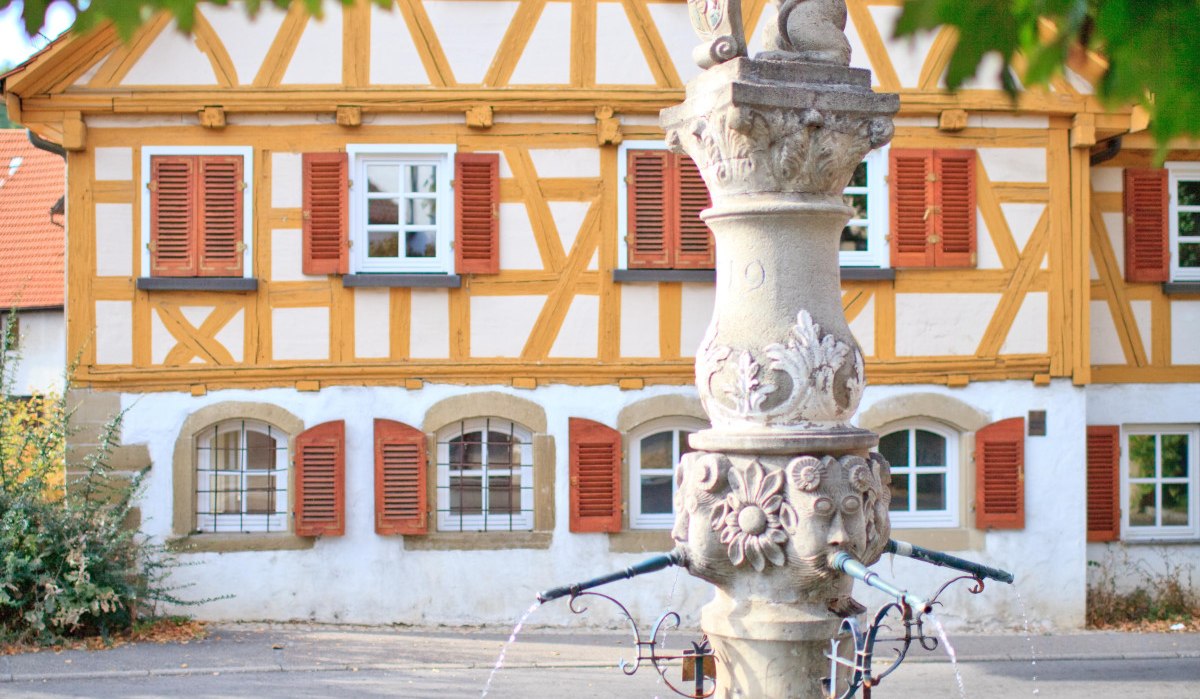 Löwenbrunnen in Waiblingen-Beinstein vor einem Fachwerkhaus. Der Brunnen hat eine Löwenfigur und sprudelndes Wasser, umgeben von Bäumen., © Waiblingen - Stuttgart-Marketing GmbH Löwenbrunnen in Waiblingen-Beinstein vor einem Fachwerkhaus. Der Brunnen hat eine Löwenfigur und sprudelndes Wasser, umgeben von Bäumen., © Waiblingen - Stuttgart-Marketing GmbH
