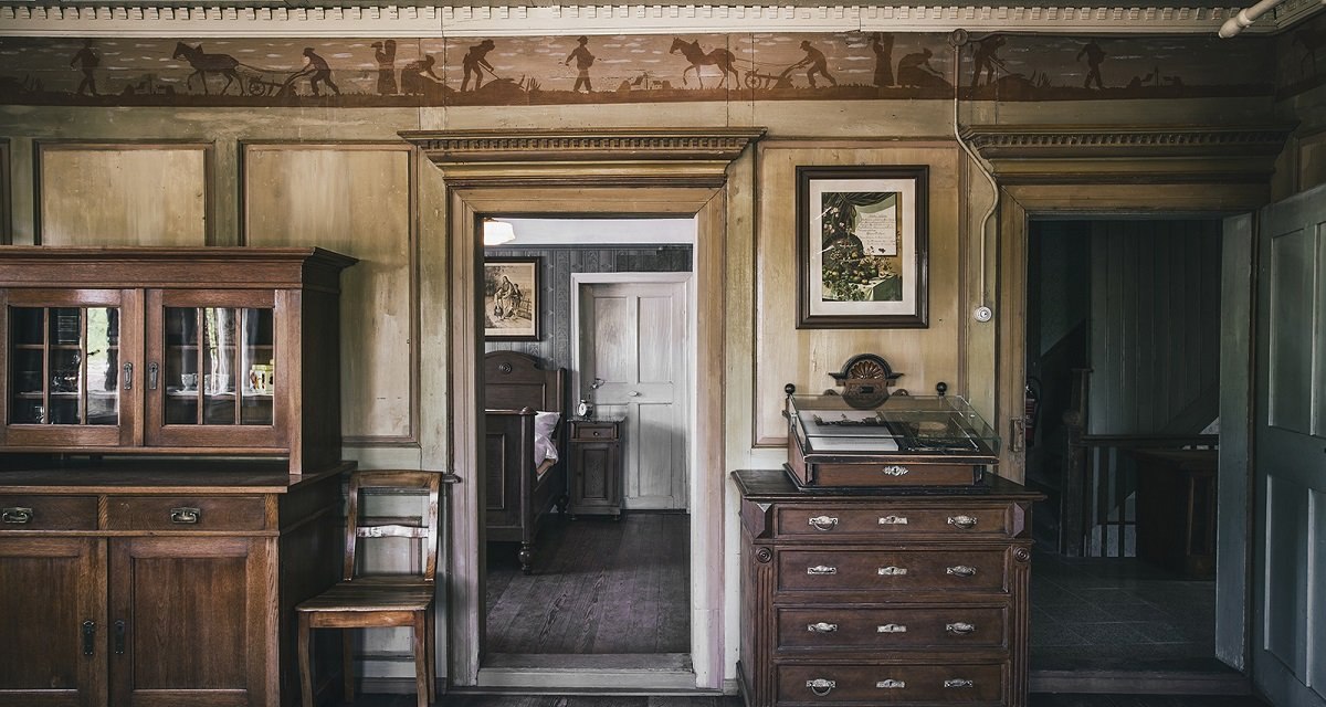 Historischer Raum mit Holzmöbeln, Wandmalereien und antiken Dekorationen. Ein Schrank, eine Kommode und ein Durchgang zu einem weiteren Raum sind sichtbar., © Unbekannt Historischer Raum mit Holzmöbeln, Wandmalereien und antiken Dekorationen. Ein Schrank, eine Kommode und ein Durchgang zu einem weiteren Raum sind sichtbar., © Unbekannt