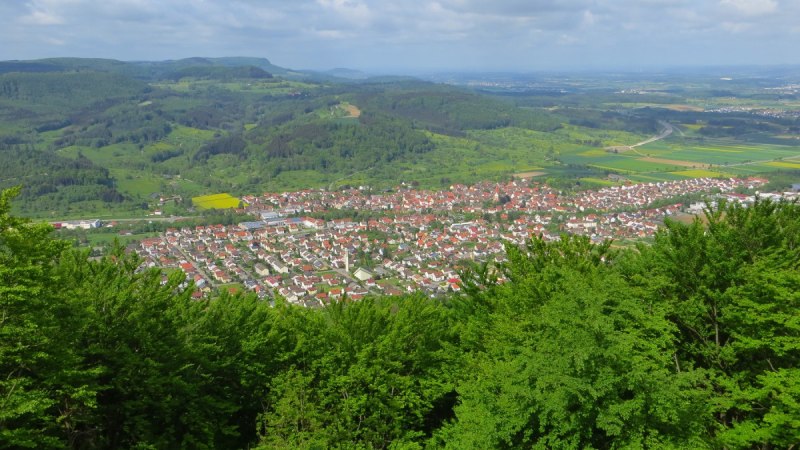 Panoramablick auf eine Stadt mit roten D&auml;chern, umgeben von gr&uuml;nen H&uuml;geln und W&auml;ldern unter einem bew&ouml;lkten Himmel., &copy; Landkreis G&ouml;ppingen