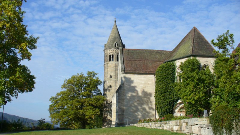 Das Bild zeigt das Kloster Lorch mit einem markanten Turm, umgeben von B&auml;umen und einer Wiese unter blauem Himmel., &copy; Remstal Tourismus e.V.