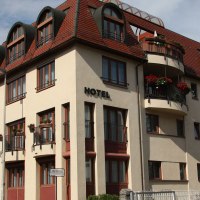 Ein mehrstöckiges Hotel mit roten Dächern und Balkonen, umgeben von anderen Gebäuden und Bäumen., © City Hotel Sindelfingen Ein mehrstöckiges Hotel mit roten Dächern und Balkonen, umgeben von anderen Gebäuden und Bäumen., © City Hotel Sindelfingen