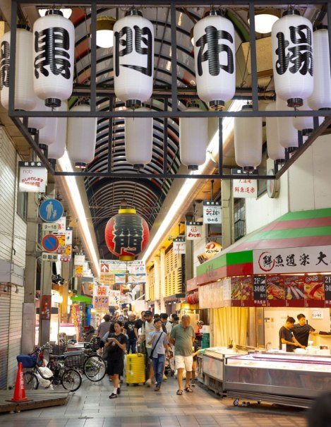 Ein belebter japanischer Markt mit traditionellen Laternen und zahlreichen Gesch&auml;ften. Menschen schlendern durch die G&auml;nge und erkunden die Angebote., &copy; Daniel Hikel
