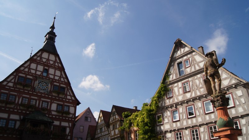 Fachwerkhäuser und eine Statue auf dem Marktplatz in Besigheim unter blauem Himmel., © Stuttgart-Marketing GmbH (SMG) Fachwerkhäuser und eine Statue auf dem Marktplatz in Besigheim unter blauem Himmel., © Stuttgart-Marketing GmbH (SMG)