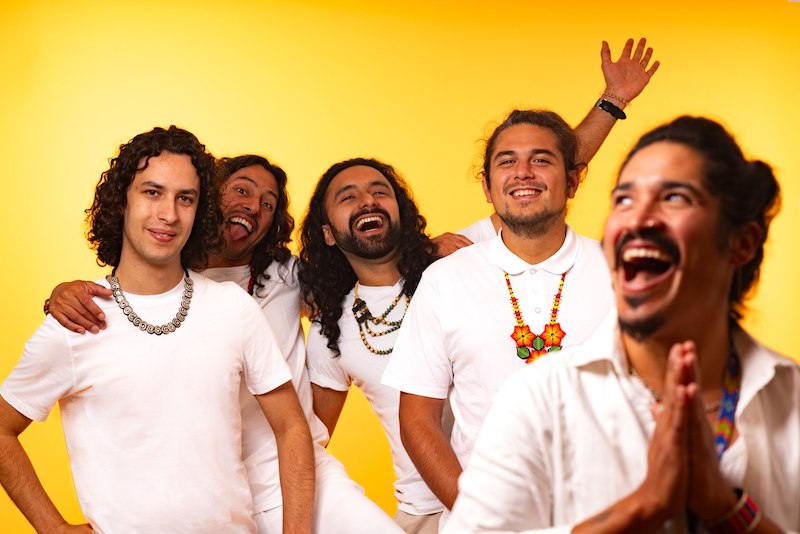 F&uuml;nf M&auml;nner in wei&szlig;en Hemden posieren fr&ouml;hlich vor einem leuchtend gelben Hintergrund. Sie lachen und wirken ausgelassen., &copy; Kulturhaus Schwanen