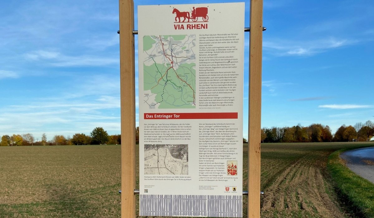Infotafel über das Entringer Tor auf einem Feldweg, umgeben von Feldern und Bäumen, unter blauem Himmel., © Natur.Nah. Schönbuch & Heckengäu Infotafel über das Entringer Tor auf einem Feldweg, umgeben von Feldern und Bäumen, unter blauem Himmel., © Natur.Nah. Schönbuch & Heckengäu