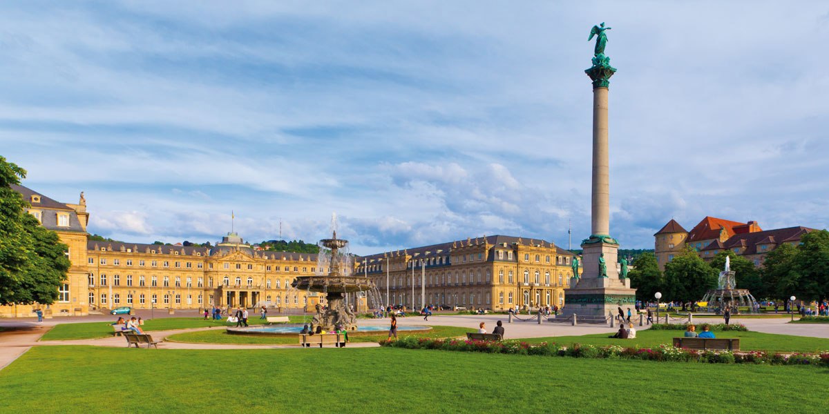 Der Schlossplatz in Stuttgart mit dem Neuen Schloss, der Jubiläumssäule und Brunnen. Menschen spazieren und entspannen auf dem grünen Platz., © SMG