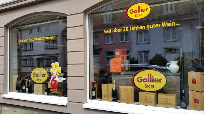 Schaufenster des Gallier Stores in Nürtingen mit Weinflaschen und Holzkisten. Aufschrift: "Seit über 30 Jahren guter Wein..." und "Auf den Geschmack kommen"., © Weinhaus Gallier