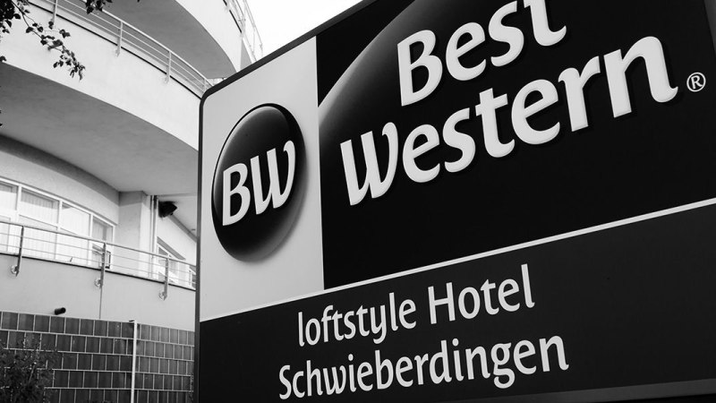 Schwarz-weißes Schild des Best Western loftstyle Hotels Schwieberdingen vor einem modernen Gebäude., © Best Western loftstyle hotel Schwieberdingen Schwarz-weißes Schild des Best Western loftstyle Hotels Schwieberdingen vor einem modernen Gebäude., © Best Western loftstyle hotel Schwieberdingen