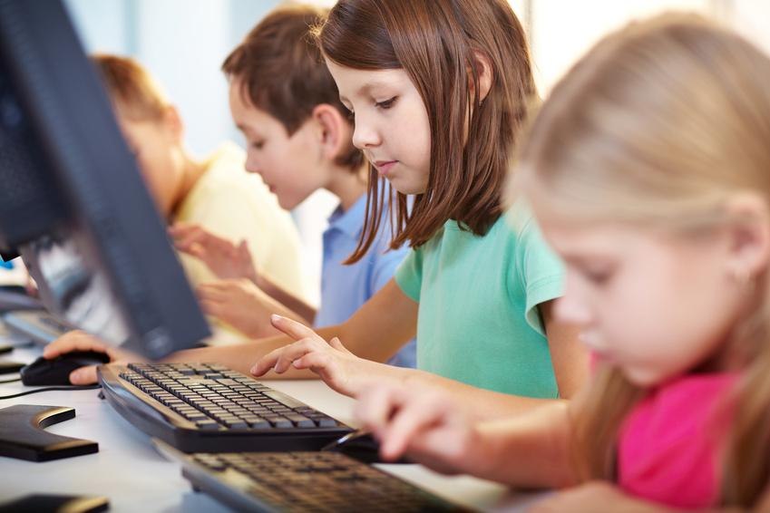 Kinder sitzen nebeneinander an Computern und tippen konzentriert auf Tastaturen. Sie sind in einem Klassenzimmer oder Computerraum., &copy; Fotalia