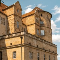 Ein altes Schloss mit markanten Türmen und vielen Fenstern, umgeben von einem blauen Himmel und einigen Wolken., © Stuttgart-Marketing GmbH, Sarah Schmid