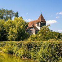 Ein malerischer See im Stadtpark von Murrhardt mit üppiger Vegetation und einem Fachwerkhaus im Hintergrund bei sonnigem Wetter., © SMG, Sarah Schmid Ein malerischer See im Stadtpark von Murrhardt mit üppiger Vegetation und einem Fachwerkhaus im Hintergrund bei sonnigem Wetter., © SMG, Sarah Schmid