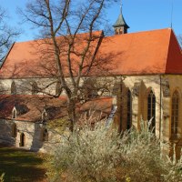 Die Schlosskirche in Winnenden mit rotem Ziegeldach und gotischen Fenstern, umgeben von herbstlichen Bäumen unter blauem Himmel., © SWT Die Schlosskirche in Winnenden mit rotem Ziegeldach und gotischen Fenstern, umgeben von herbstlichen Bäumen unter blauem Himmel., © SWT