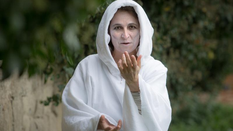 Eine Person in einem weißen Geisterkostüm steht im Schlosspark und gestikuliert geheimnisvoll. Der Hintergrund ist grün und unscharf., © © T&E, Benjamin Stollenberg Eine Person in einem weißen Geisterkostüm steht im Schlosspark und gestikuliert geheimnisvoll. Der Hintergrund ist grün und unscharf., © © T&E, Benjamin Stollenberg