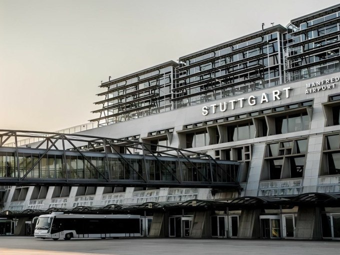 Au&szlig;enansicht des Stuttgarter Flughafens mit moderner Architektur und einem Bus im Vordergrund., &copy; Schlienz-Tours GmbH &amp; Co.KG