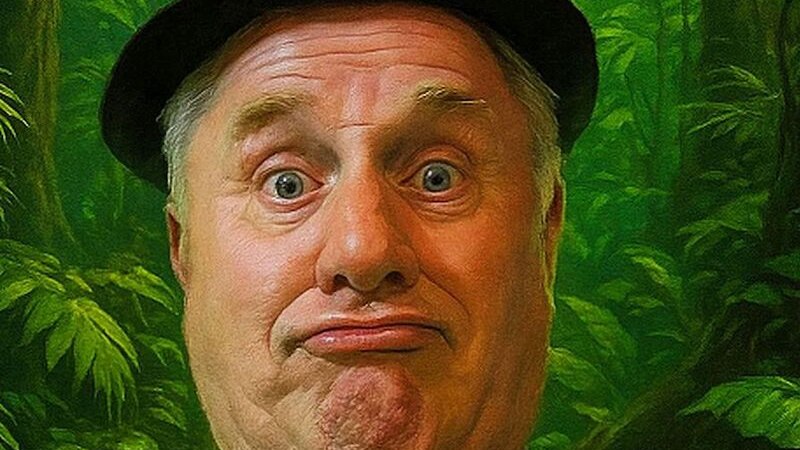 Ein Mann mit Hut zieht eine lustige Grimasse vor einem gr&uuml;nen Dschungelhintergrund. Sein Gesichtsausdruck ist humorvoll und &uuml;bertrieben., &copy; Stadthalle Leonberg