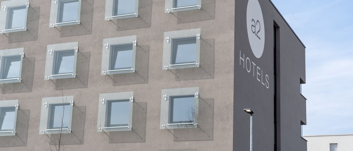 Moderne Hotel-Fassade mit quadratischen Fenstern und dem Logo von a2 HOTELS in Denkendorf., &copy; a2 HOTELS