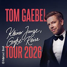 Tom Gaebel k&uuml;ndigt seine Tour 2026 'Kleiner Junge, gro&szlig;e Reise' an. Das Plakat zeigt ihn in einem eleganten Anzug vor dunklem Hintergrund., &copy; links im Bild