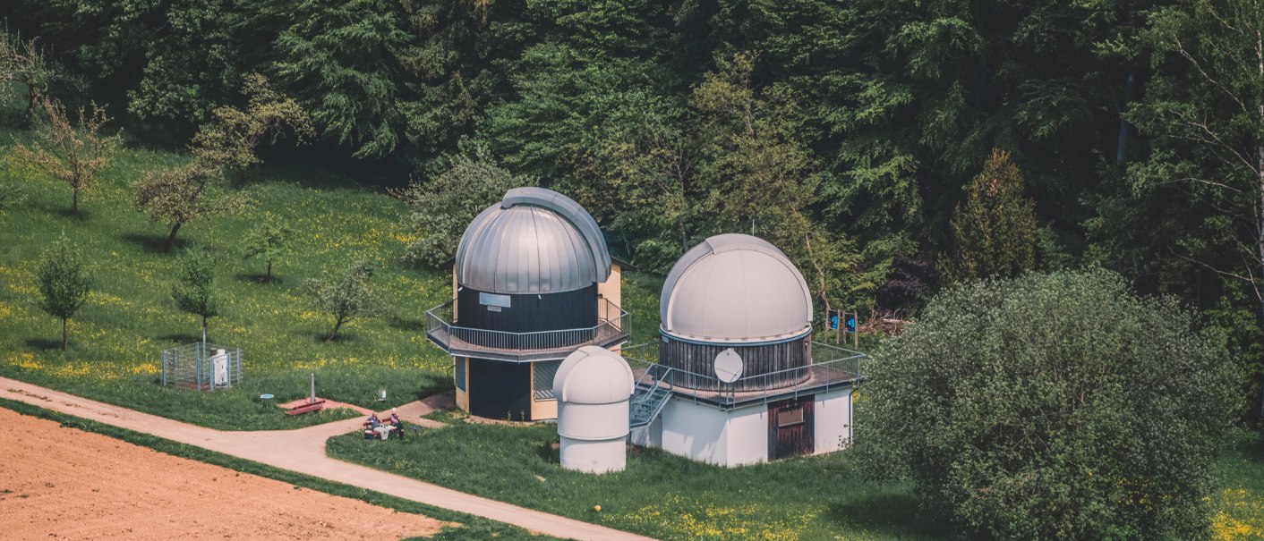 Zwei Observatoriumskuppeln stehen in einer grünen Landschaft, umgeben von Bäumen und Wiesen. Ein Weg führt an den Kuppeln vorbei., © Stadt Welzheim Zwei Observatoriumskuppeln stehen in einer grünen Landschaft, umgeben von Bäumen und Wiesen. Ein Weg führt an den Kuppeln vorbei., © Stadt Welzheim