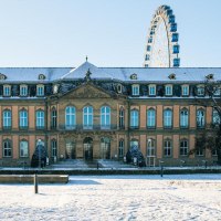 Das Neue Schloss in Stuttgart ist von Schnee bedeckt. Im Hintergrund ist ein Riesenrad zu sehen, das in den blauen Himmel ragt., &copy; Stuttgart-Marketing GmbH, Sarah Schmid