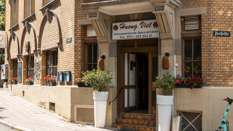 Eingang des Restaurants Huong Viet mit Blumenarrangements und einem E-Scooter auf dem Gehweg., &copy; Stuttgart Marketing GmbH, Sarah Schmid