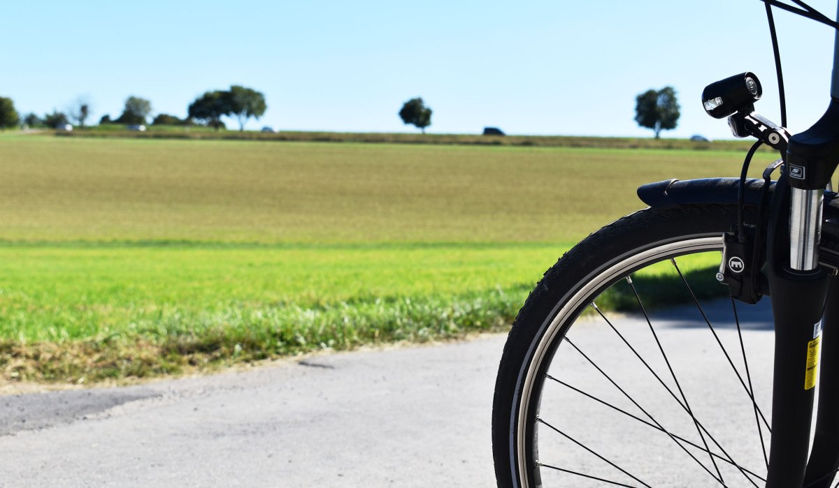 Fahrradvorderrad auf einem ländlichen Weg, im Hintergrund grüne Felder und Bäume unter klarem Himmel., © Stadtmarketing Böblingen e.V. Fahrradvorderrad auf einem ländlichen Weg, im Hintergrund grüne Felder und Bäume unter klarem Himmel., © Stadtmarketing Böblingen e.V.