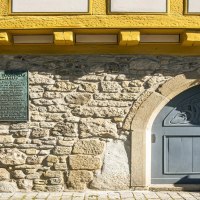 Nahaufnahme des Stadtmuseums Sindelfingen mit gelbem Fachwerk, blauer Tür und Infotafel an einer Steinwand., © SMG,  Sarah Schmid