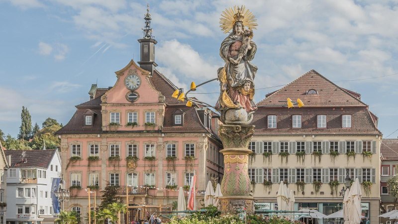 Barocke Statue auf einem Marktplatz, umgeben von historischen Gebäuden mit Fachwerk und verzierten Fassaden. Der Himmel ist leicht bewölkt., © Mario Klaiber Barocke Statue auf einem Marktplatz, umgeben von historischen Gebäuden mit Fachwerk und verzierten Fassaden. Der Himmel ist leicht bewölkt., © Mario Klaiber