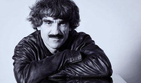 Ein Mann mit lockigem Haar und Schnurrbart tr&auml;gt eine Lederjacke und lehnt sich entspannt auf seine Arme., &copy; Stadt Esslingen am Neckar