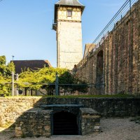 Blick auf eine historische Burgmauer und ein Fachwerkgebäude in Marbach am Neckar. Der Himmel ist klar und blau., © Stuttgart-Marketing GmbH, Sarah Schmid