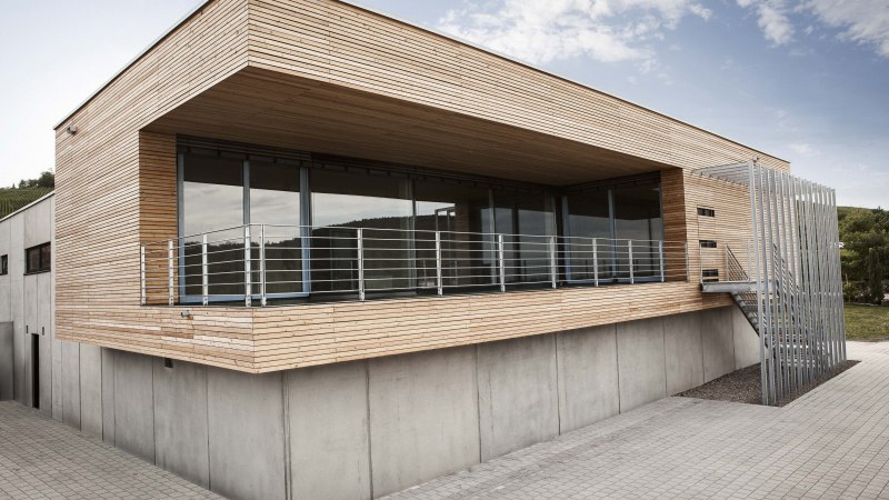 Modernes Gebäude mit Holzverkleidung, großen Fenstern und Metallgeländer. Außenansicht bei Tageslicht, klare Linien und minimalistisches Design., © Weingut Knauß Modernes Gebäude mit Holzverkleidung, großen Fenstern und Metallgeländer. Außenansicht bei Tageslicht, klare Linien und minimalistisches Design., © Weingut Knauß