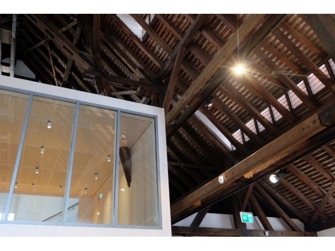 Holzdachkonstruktion mit Glaswand im Weinbaumuseum. Moderne Beleuchtung und Notausgangsschild sichtbar., &copy; Stuttgart Marketing GmbH