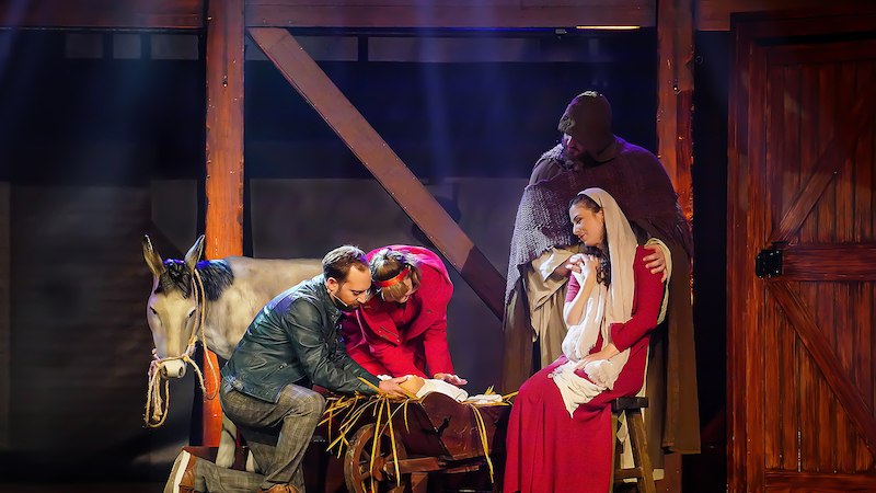 Schauspieler stellen eine Krippenszene dar, mit einem Esel, einer Krippe und Figuren in historischen Kostümen auf einer Bühne., © Wacky Productions GmbH