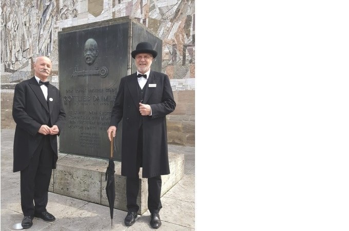 Zwei Männer in historischer Kleidung posieren vor einem Gottlieb-Daimler-Denkmal in Schorndorf. Sie tragen Anzüge und Hüte und halten Regenschirme., © Eigenbetrieb Tourismus und Citymanagement Schorndorf Zwei Männer in historischer Kleidung posieren vor einem Gottlieb-Daimler-Denkmal in Schorndorf. Sie tragen Anzüge und Hüte und halten Regenschirme., © Eigenbetrieb Tourismus und Citymanagement Schorndorf