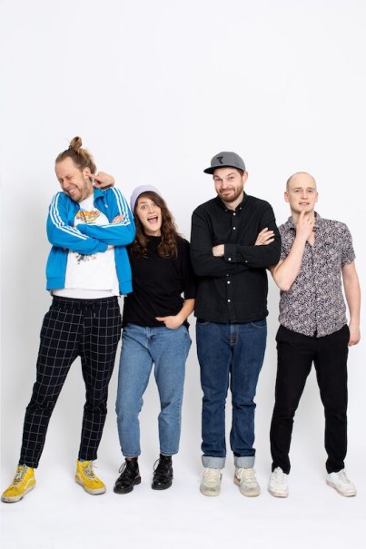 Vier Personen stehen lächelnd vor einem weißen Hintergrund. Sie tragen lässige Kleidung und wirken entspannt und fröhlich., © Interessengemeinschaft Kultur Sindelfingen / Böblingen e.V.