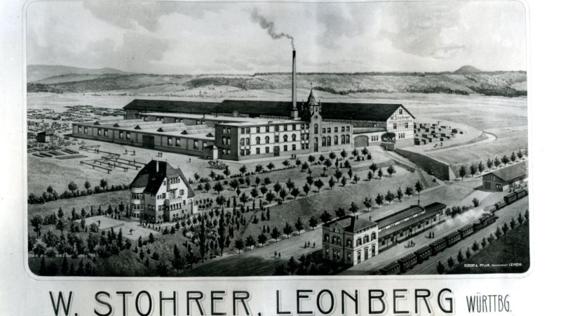 Historische Zeichnung der Maschinenfabrik W. Stohrer in Leonberg mit großen Gebäuden, Schornstein und umliegenden Anlagen. Im Vordergrund sind Bäume und ein Zug zu sehen., © Stadtarchiv Leonberg Historische Zeichnung der Maschinenfabrik W. Stohrer in Leonberg mit großen Gebäuden, Schornstein und umliegenden Anlagen. Im Vordergrund sind Bäume und ein Zug zu sehen., © Stadtarchiv Leonberg