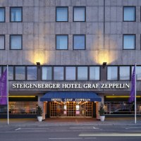 Außenansicht des Steigenberger Hotel Graf Zeppelin mit beleuchtetem Eingang und Fahnen., © Steigenberger Graf Zeppelin Außenansicht des Steigenberger Hotel Graf Zeppelin mit beleuchtetem Eingang und Fahnen., © Steigenberger Graf Zeppelin
