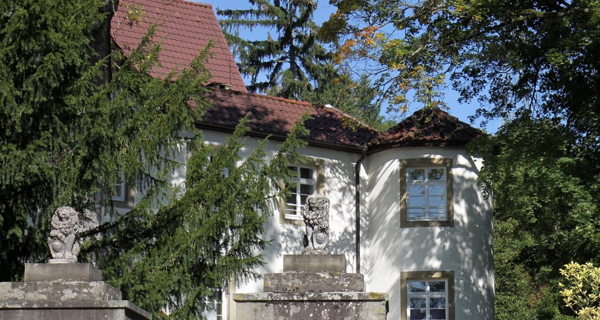 Ein Schloss in Riet mit roten Ziegeld&auml;chern, umgeben von B&auml;umen. Zwei steinerne L&ouml;wenstatuen stehen auf S&auml;ulen im Vordergrund., &copy; Land der 1000 H&uuml;gel - Kraichgau-Stromberg