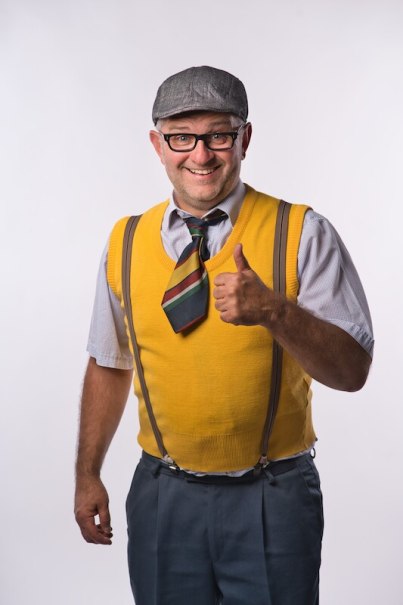 Mann mit gelbem Pullunder, gestreifter Krawatte und Schiebermütze zeigt Daumen hoch und lächelt in die Kamera., © Kurverwaltung Bad Urach