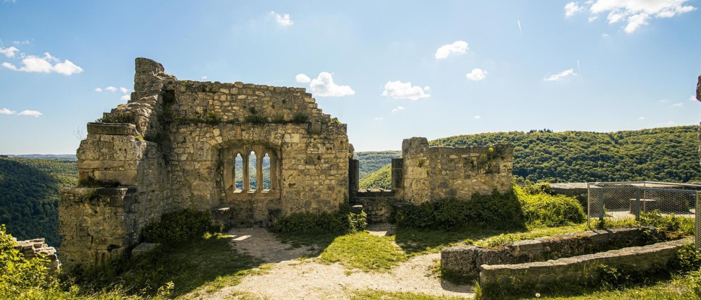Ruine der Burg Hohenurach in Bad Urach, umgeben von grünen Hügeln und blauem Himmel. Die Steinmauern sind teilweise erhalten., © Stuttgart-Marketing GmbH, Sarah Schmid Ruine der Burg Hohenurach in Bad Urach, umgeben von grünen Hügeln und blauem Himmel. Die Steinmauern sind teilweise erhalten., © Stuttgart-Marketing GmbH, Sarah Schmid