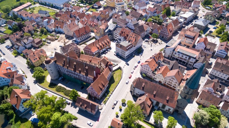 Luftaufnahme einer historischen Altstadt mit Fachwerkh&auml;usern, Schloss und Kirche. Die Stra&szlig;en sind von B&auml;umen ges&auml;umt., &copy; Stadt Gaildorf