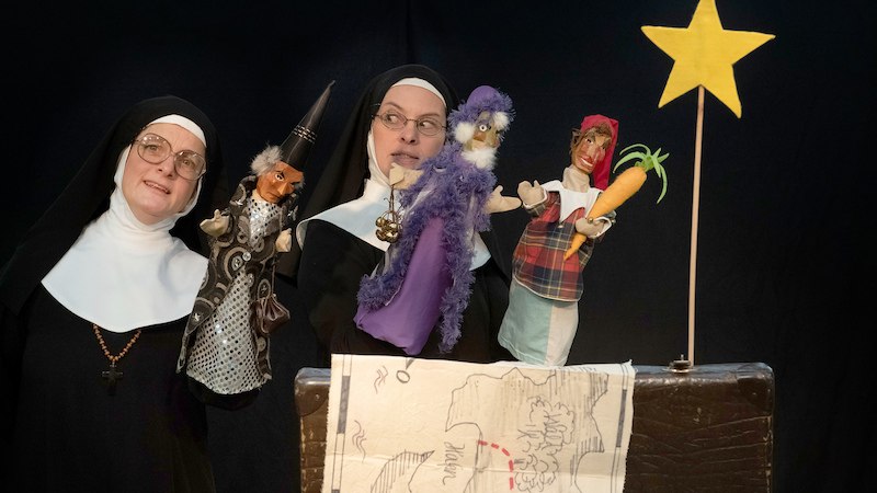 Zwei Nonnen halten Handpuppen in einem Puppenspiel. Eine Karte und ein gelber Stern sind im Vordergrund sichtbar., © Stadt Leinfelden-Echterdingen, Kulturamt