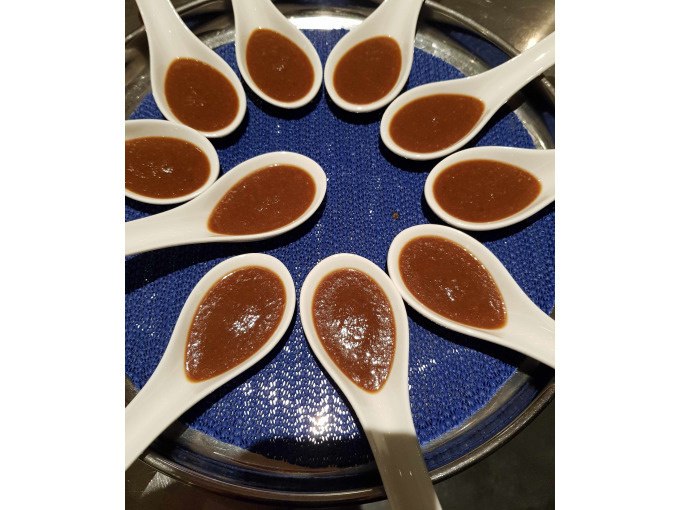 Wei&szlig;e L&ouml;ffel mit brauner Sauce sind kreisf&ouml;rmig auf einem blauen Tablett angeordnet., &copy; Kultweine-Kochwelten-Kunst&uuml;cke - Kochschule Sonja Lenz