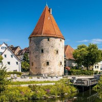 Der historische Pulverturm in Vaihingen an der Enz, umgeben von malerischen Häusern und einem ruhigen Fluss unter blauem Himmel., © SMG, Sarah Schmid Der historische Pulverturm in Vaihingen an der Enz, umgeben von malerischen Häusern und einem ruhigen Fluss unter blauem Himmel., © SMG, Sarah Schmid