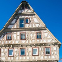Ein traditionelles Fachwerkhaus in Besigheim, umgeben von klarem, blauem Himmel. Links ist eine gr&uuml;ne Pflanze zu sehen., &copy; Stuttgart-Marketing GmbH, Sarah Schmid